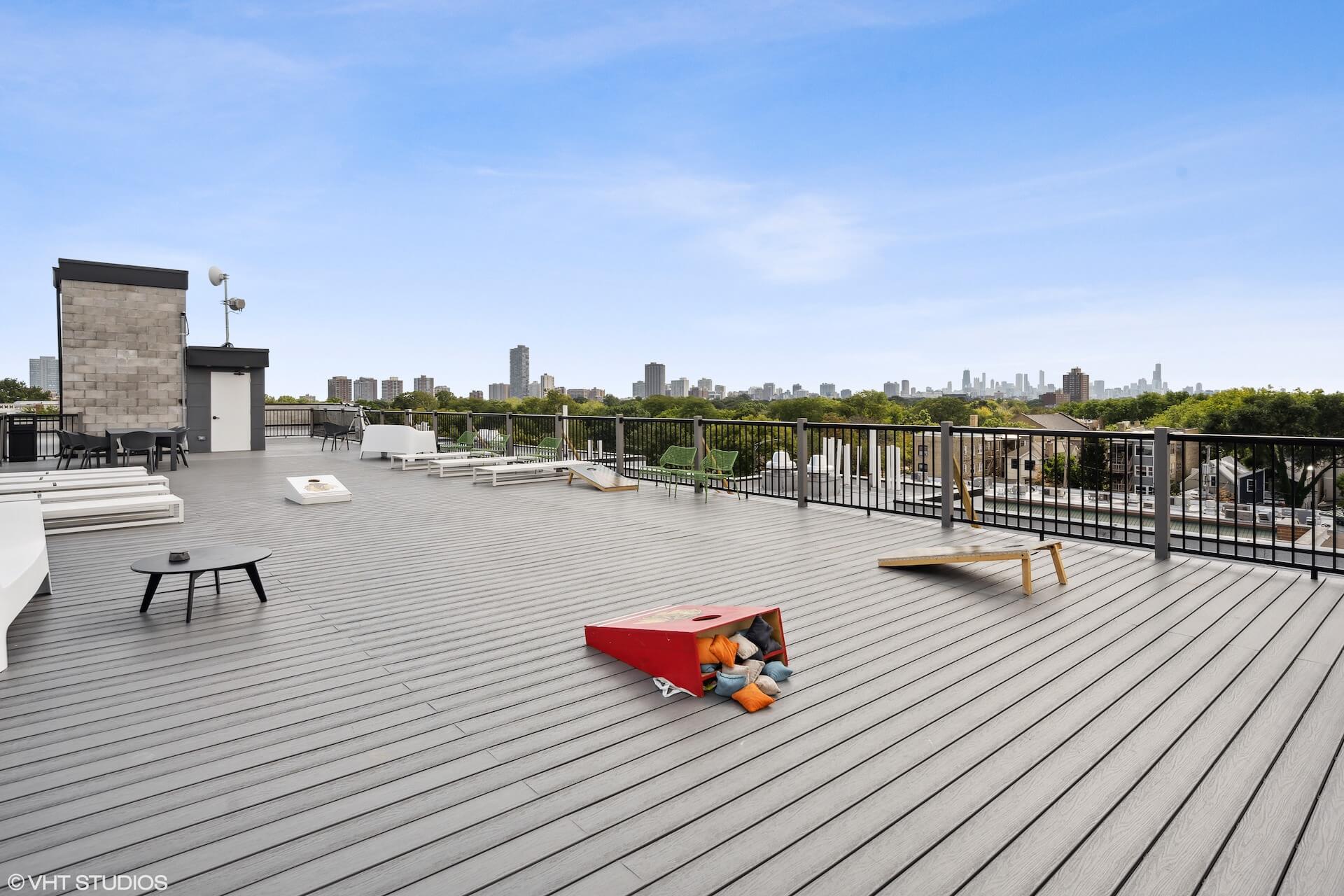 Private rooftop deck with lounge seating and corn hole games.